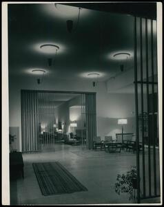 A room with sitting areas and a wooden room divider