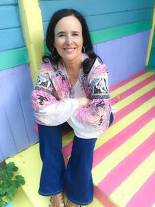 Rudio Behar sitting on a colorfully-painted pastel porch