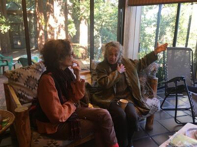 Wendy Perron and Anna Halprin sitting in an enclosed porch, speaking to each other