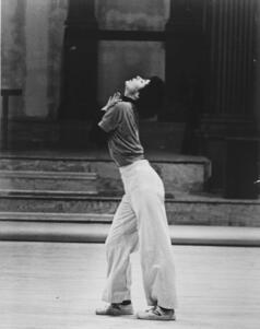 Wendy Perron dancing, looking up, wearing loose clothing and sneakers