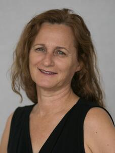 Woman with brown shoulder-length hair and black tank top