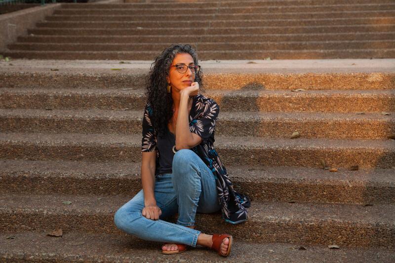 photo of a woman with long curly hair sitting on outdoor stairs