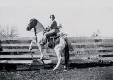 Frances Kallison and horse posed in front of wooden fence