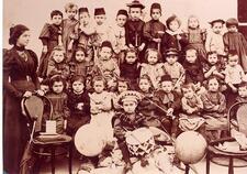 Group photo of kindergarteners, with woman teacher at left