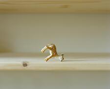 Photo of toy deer figurine upside on book shelf