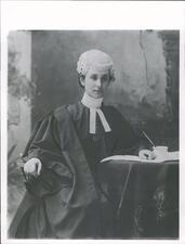 black and white photograph of a woman in black robes with a white wig