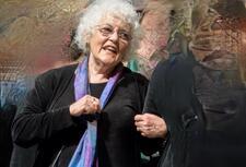 photograph of a woman with white hair singing in a chorus