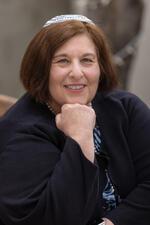 photo of a woman with her hand on a chin wearing a kippah