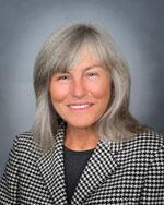 photo of a woman with shoulder-length light hair wearing a black and white checked jacket