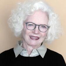 photograph of a woman with white hair wearing a dark sweater