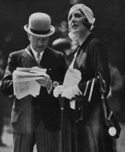 Germaine de Rothschild standing beside André Citroën, reading a newspaper