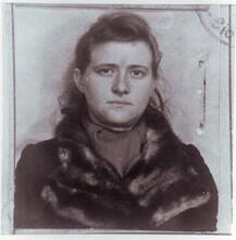 A square photo of young Haika Grossman, wearing a fur collar coat, with a stamp in the corner