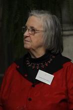 photograph of a woman with gray hair wearing a red dress