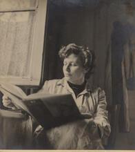 Black and white photo of artist Ruth Schloss with a large book