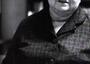 black and white photograph of an older woman with white hair holding a newspaper