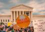  Protesters holding signs outside Supreme Court on Day Roe v Wade was overturned