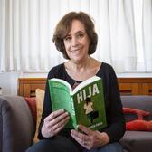 Ana Maria Shua posing reading her book, Hija