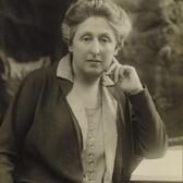 Cécile Brunschvicg sitting at a desk, with her elbow resting on an open book