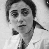 Portrait of Carol Nadelson speaking while wearing white lab coat and name tag