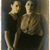 Hilda Purwitsky and Roza Van Gelderen looking to camera with hands touching