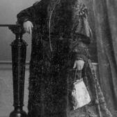 Full-length portrait of Pauline Wengeroff, wearing a floor-length dress and a fur drape