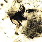 Hester Martinez in a rocky area covered with scrub, posing with her hat in her hand