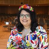 photograph of a woman with dark hearing wearing a flower crown and a colorful shirt