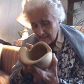 photograph of a woman with white hair working on pottery