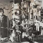 black and white photograph of a woman in a lab surrounded by lab equipment