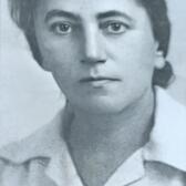 black and white photograph of a woman with dark hair pulled back, looking seriously at the camera