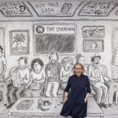New Yorker cartoonist, Roz Chast stands in front of mural