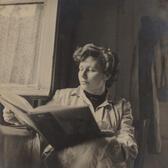 Black and white photo of artist Ruth Schloss with a large book