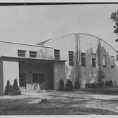 The exterior of a gymnasium with a curved roof