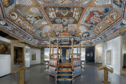 Reconstruction of the colorful painted ceiling, timber-frame roof, and bimah of the wooden synagogue
