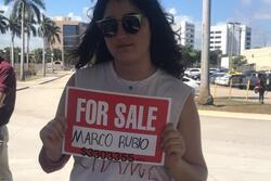 Lila Goldstein holding a sign that reads "For Sale: Marco Rubio"