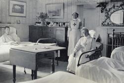 A man lying in a hospital bed with two nurses in uniform