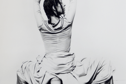 Ze'eva Cohen dancing, squatting low over some pieces of pottery with her wrists crossed above her head