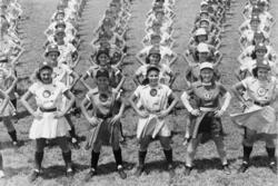 Rows of young women in baseball uniforms with hands on hips