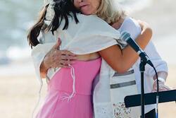 Aviva hugging her grandmother at her bat mitzvah, wearing her tallit
