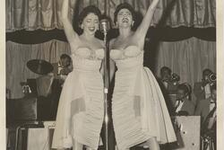 Black-and-white photo of two women on stage