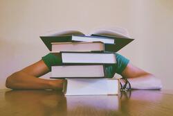 Student Sitting Behind Books