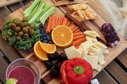 A charcuterie board with cheese and fruit
