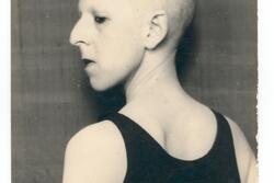 black and white photograph in profile of a figure with a shaved head