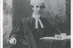 black and white photograph of a woman in black robes with a white wig