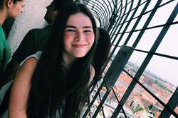 Ilana Drake standing in a passageway on the Bell Tower of St. Paul's Church, Munich cityscape below.