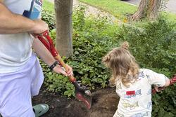 Father and daughter digging a hole for placenta burial