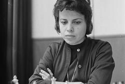 black and white photograph of a woman with short dark hair playing chess