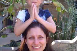 Woman with girl on her shoulders who had her hands in prayer position