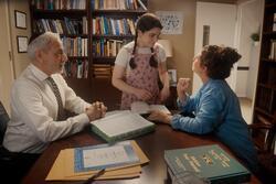 Photo of a teenager girl talking to her mother and a rabbi in the rabbi's office