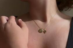 Photo of person wearing a Star of David necklace and the letter M